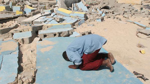 A villager prays on the remains of the mosque, Somalia