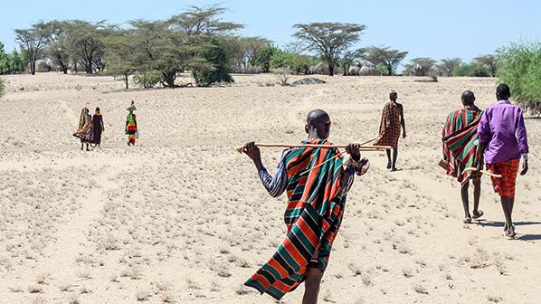 Pastoralist Turkana people walking across dry, hot land