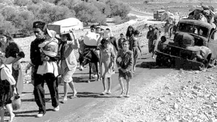 A group of Palestine refugees (British Mandate of Palestine - 1948) walking along a road, making their way from Galilee in October-November 1948.