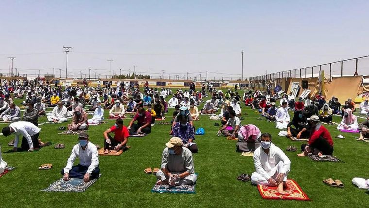 Syrian refugees attend Friday prayers outside, socially-distanced, following COVID-19 restrictions at Za'atari refugee camp