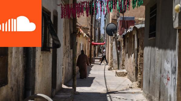a woman walking down a narrow street in Amman