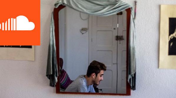 A Syrian refugee reflected in a mirror teaches Arabic via Skype
